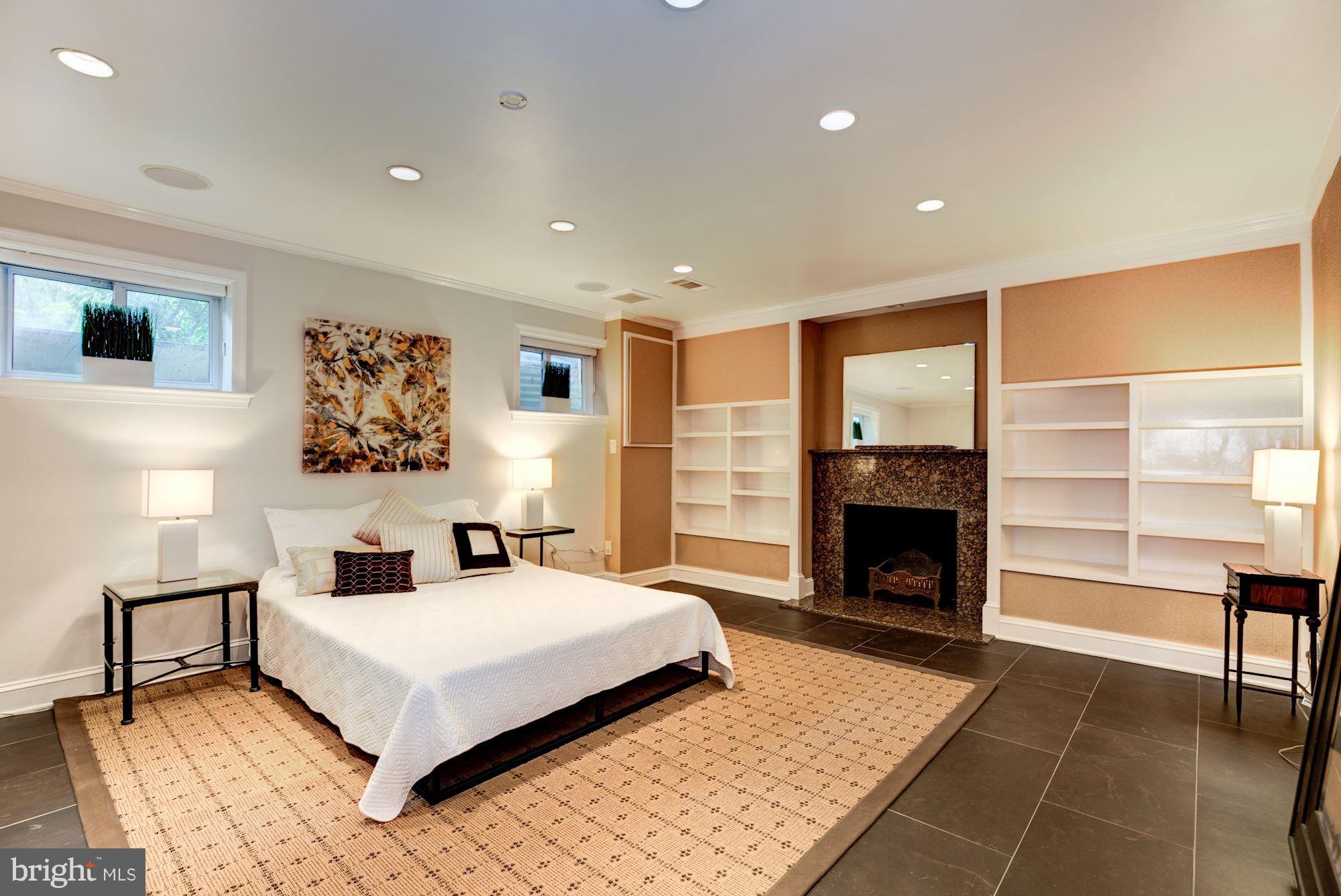 2205 46th Street Northwest Washington, DC 20007 - Photo 25 of 30 a bedroom with a large bed and a fireplace