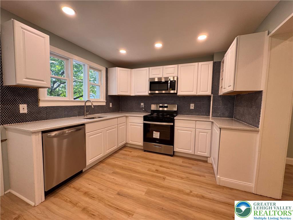 35 North 5th Street Easton, PA 18042 - Photo 20 of 96 a kitchen with kitchen island granite countertop a sink cabinets and stainless steel appliances