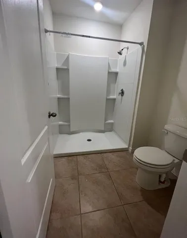 a bathroom with a toilet and a shower
