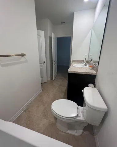 a white toilet sitting next to a bathroom sink and a mirror