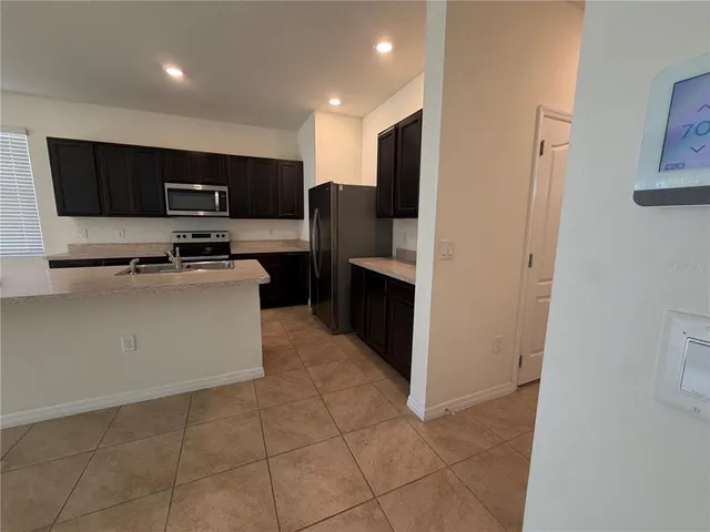 a kitchen with stainless steel appliances a stove a sink a microwave a refrigerator and cabinets