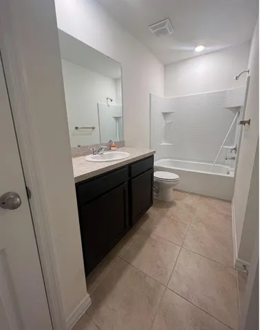 a bathroom with a sink and mirror with bathtub