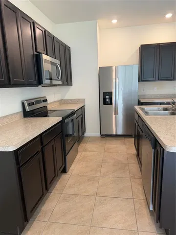a kitchen with stainless steel appliances a stove a refrigerator and a sink