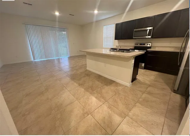 a kitchen with stainless steel appliances a stove top oven a sink a counter top space and cabinets