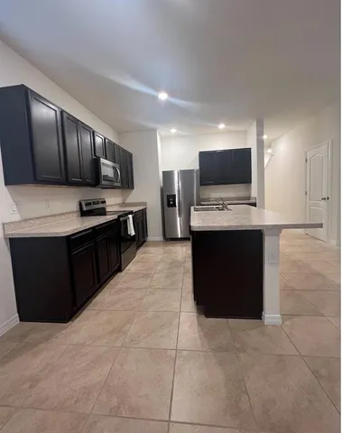 a kitchen with kitchen island granite countertop a stove and a sink