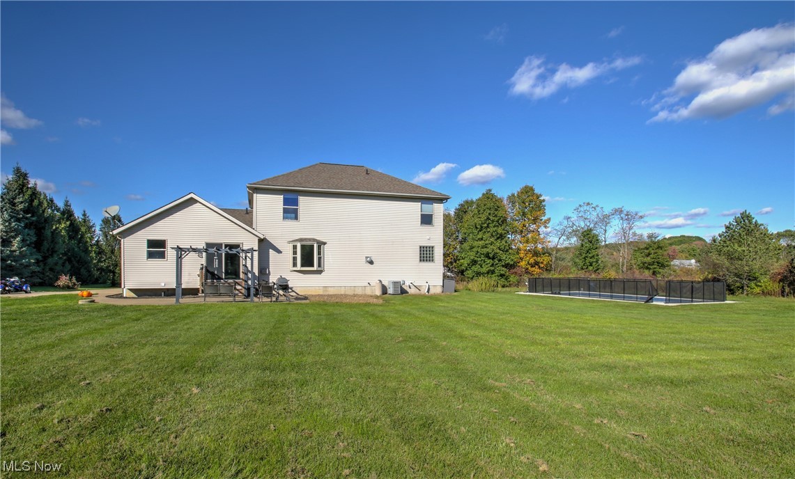 4998 Wayne Road Mantua, OH 44255 - Photo 36 of 43 Rear view of property with a yard, a patio, and a trampoline
