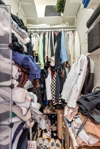 a view of walk in closet with clothes and shoes