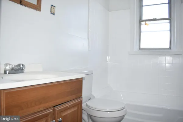 a bathroom with a sink a toilet and a window