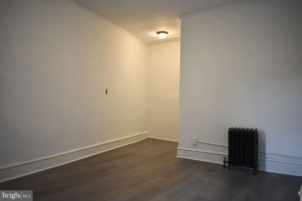 a view of a room with wooden floor and a window