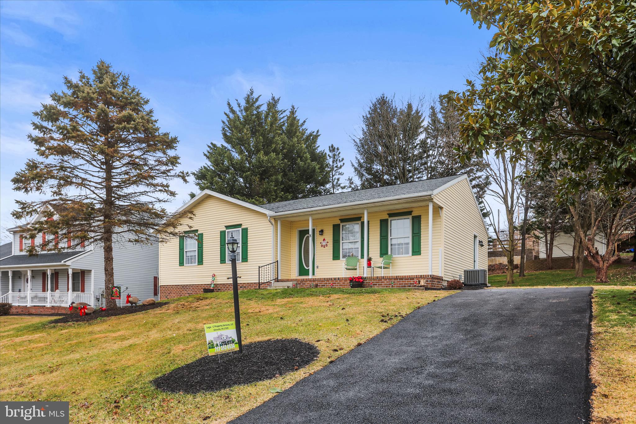 a front view of a house with a yard and trees