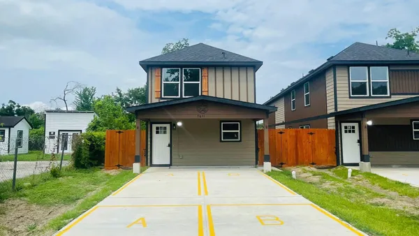 a front view of a house with a garden