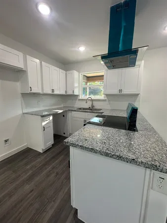 a kitchen with stainless steel appliances granite countertop a sink stove and cabinets