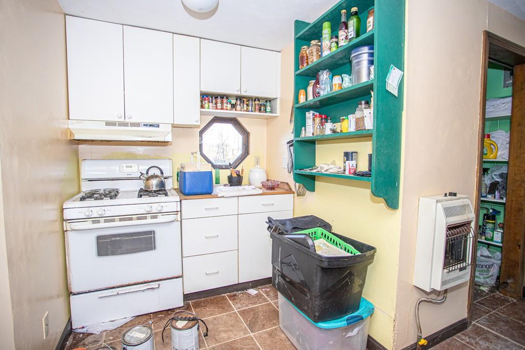 75 Cobb Hill Road Phillipston, MA 01331 - Photo 10 of 42 a kitchen with a stove top oven and a clock on the wall