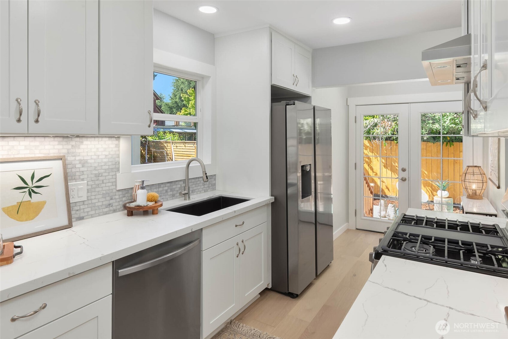 1312 Northeast 70th Street Seattle, WA 98115 - Photo 11 of 36 a kitchen with stainless steel appliances a refrigerator a sink a stove and cabinets
