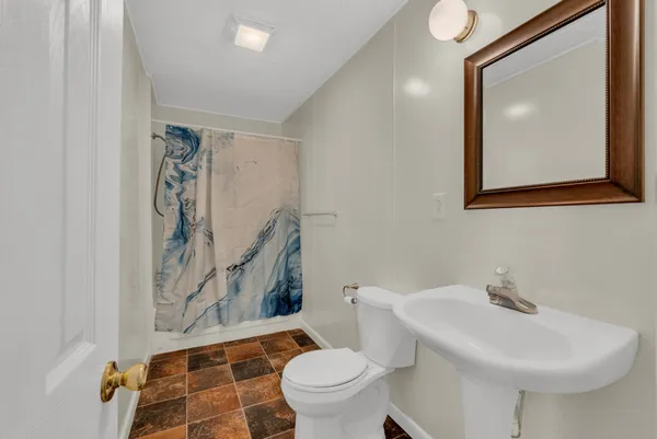 a bathroom with a toilet sink and mirror