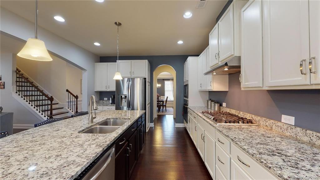 6018 Fallondale Road Waxhaw, NC 28173 - Photo 11 of 48 a large kitchen with stainless steel appliances kitchen island a large counter top a stove and a sink