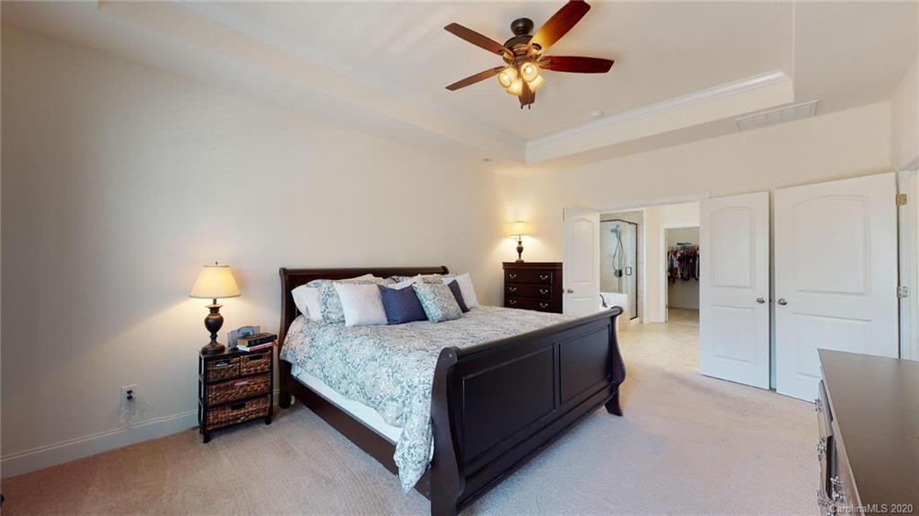 6018 Fallondale Road Waxhaw, NC 28173 - Photo 24 of 48 a bedroom with a bed and a chandelier