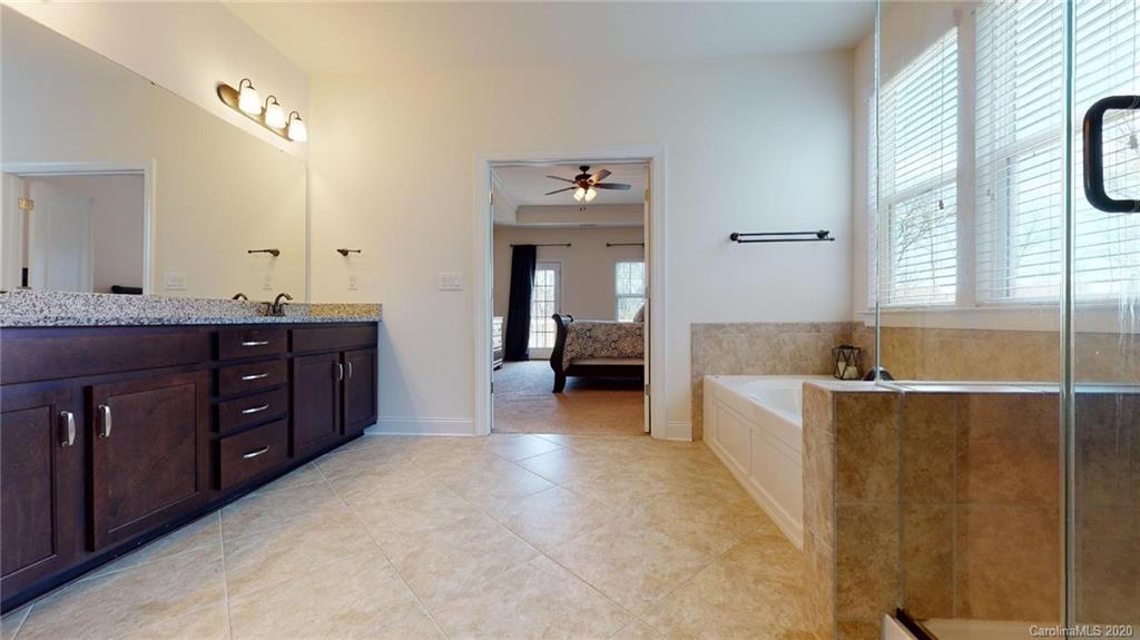 6018 Fallondale Road Waxhaw, NC 28173 - Photo 26 of 48 a spacious bathroom with a tub sink and mirror