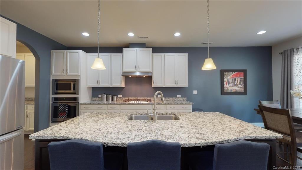 6018 Fallondale Road Waxhaw, NC 28173 - Photo 9 of 48 a kitchen with kitchen island granite countertop a wooden cabinets and refrigerator