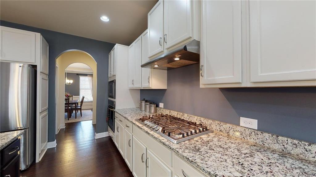6018 Fallondale Road Waxhaw, NC 28173 - Photo 10 of 48 a kitchen with stainless steel appliances granite countertop a stove and a wooden floors