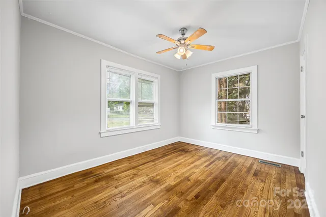 a view of an empty room with a window and closet area