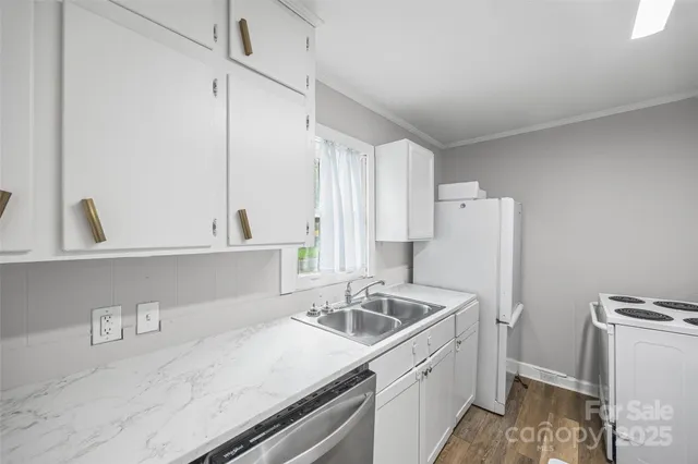 a kitchen that has a sink cabinets counter space and appliances