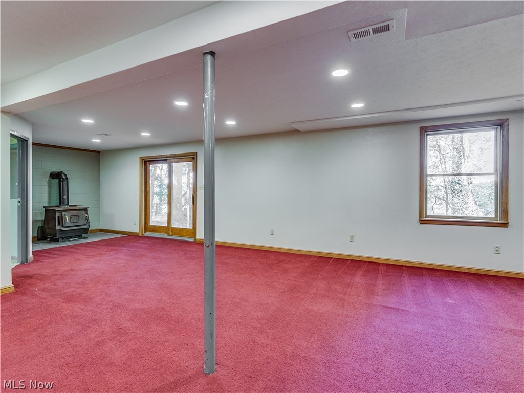 6644 Red Brush Road Ravenna, OH 44266 - Photo 28 of 35 Now we're in the lower level. A second wood burning stove sits near the sliders to the back patio.