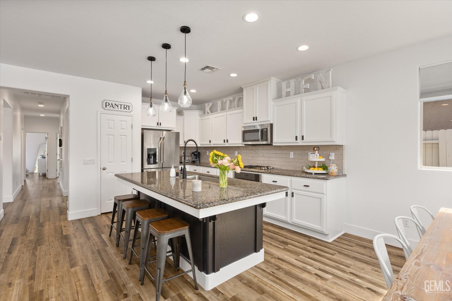 Undisclosed Address Bakersfield, CA 93314 - Photo 11 of 43 a kitchen with kitchen island granite countertop a sink cabinets and stainless steel appliances