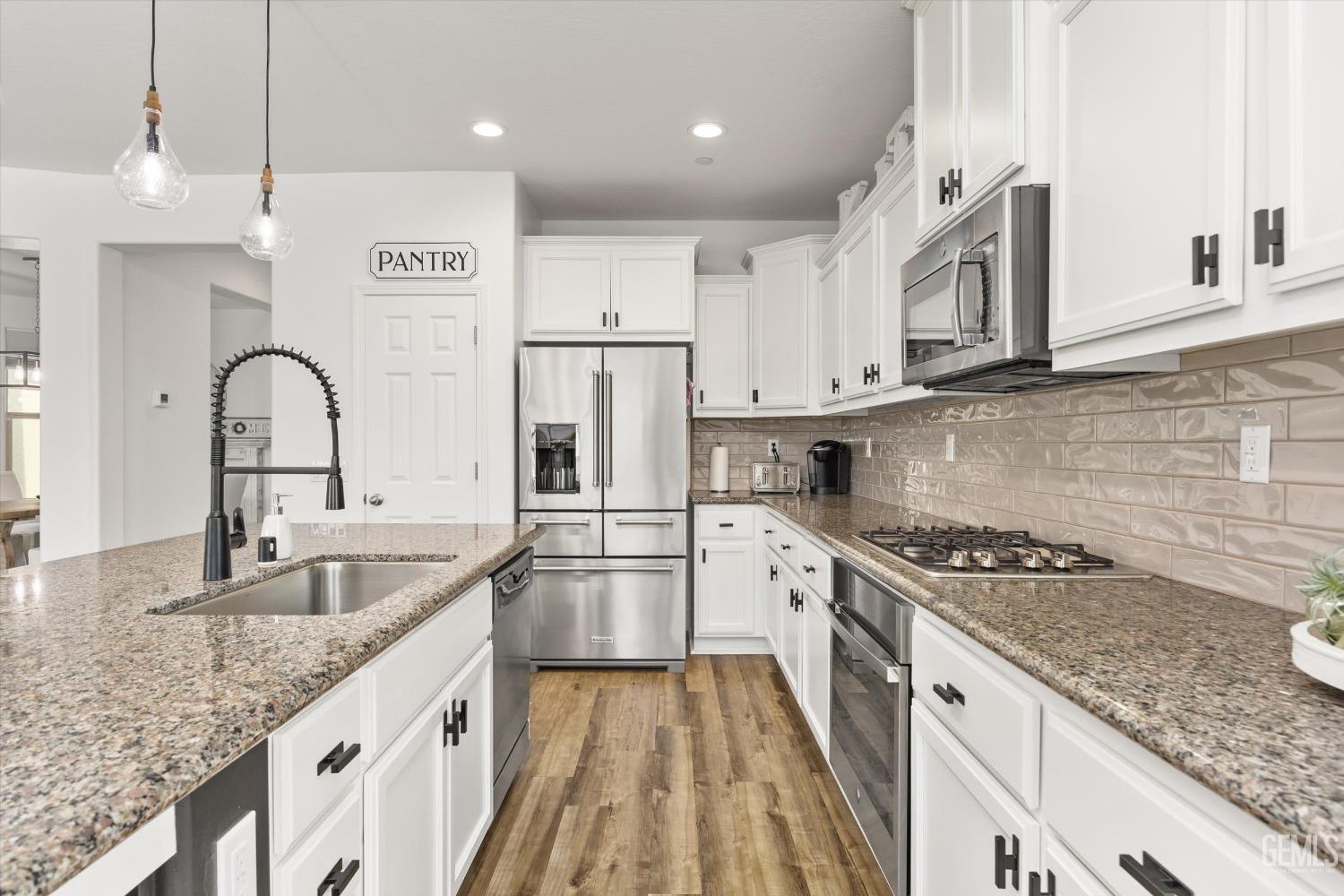Undisclosed Address Bakersfield, CA 93314 - Photo 12 of 43 a kitchen with granite countertop a sink stainless steel appliances and cabinets