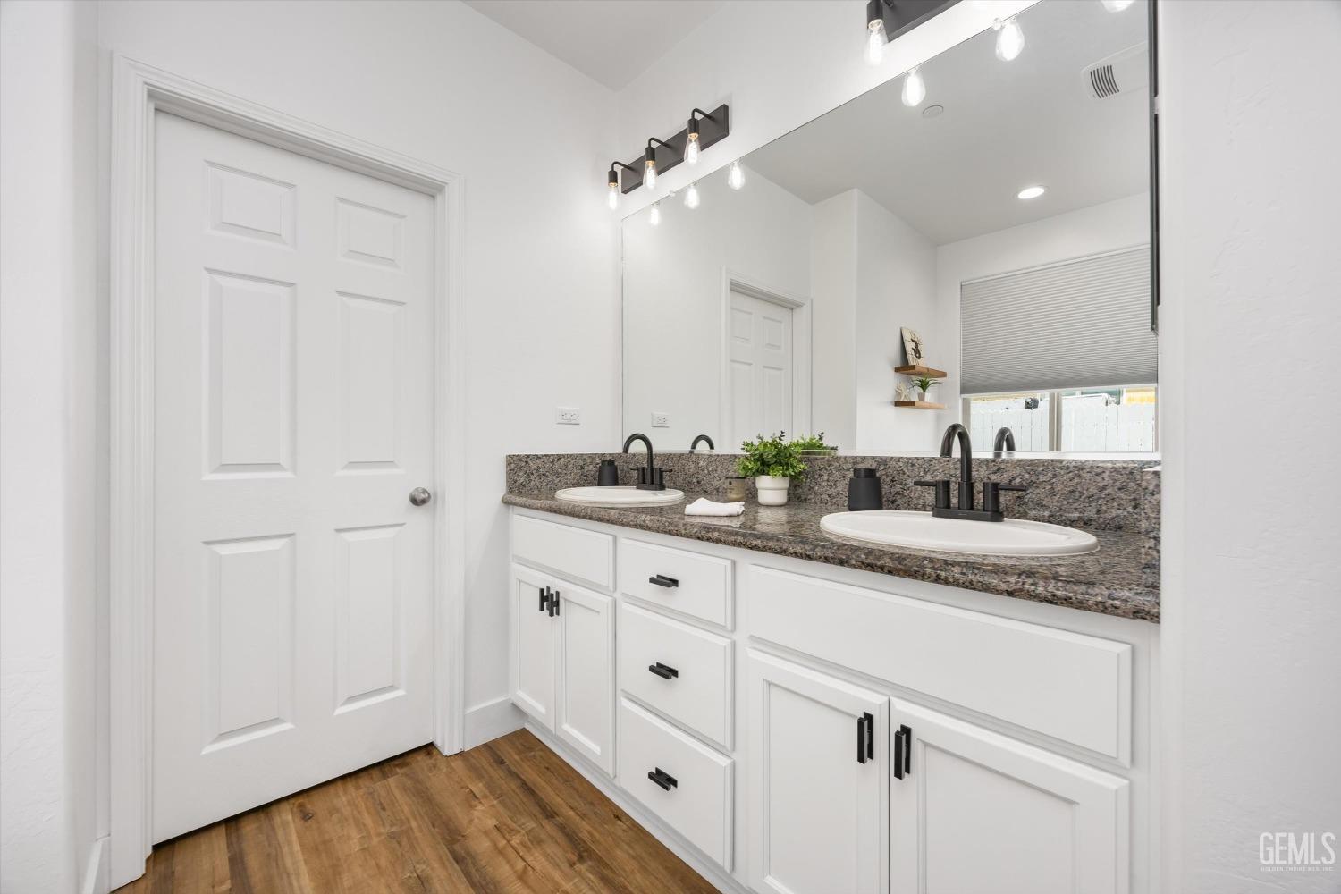 Undisclosed Address Bakersfield, CA 93314 - Photo 27 of 43 a bathroom with a granite countertop sink and a mirror