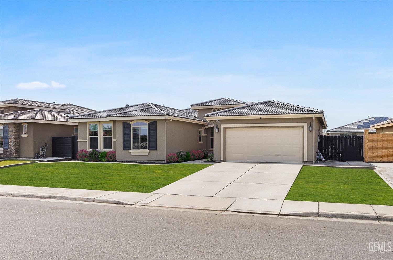 Undisclosed Address Bakersfield, CA 93314 - Photo 3 of 43 a front view of a house with a yard and garage