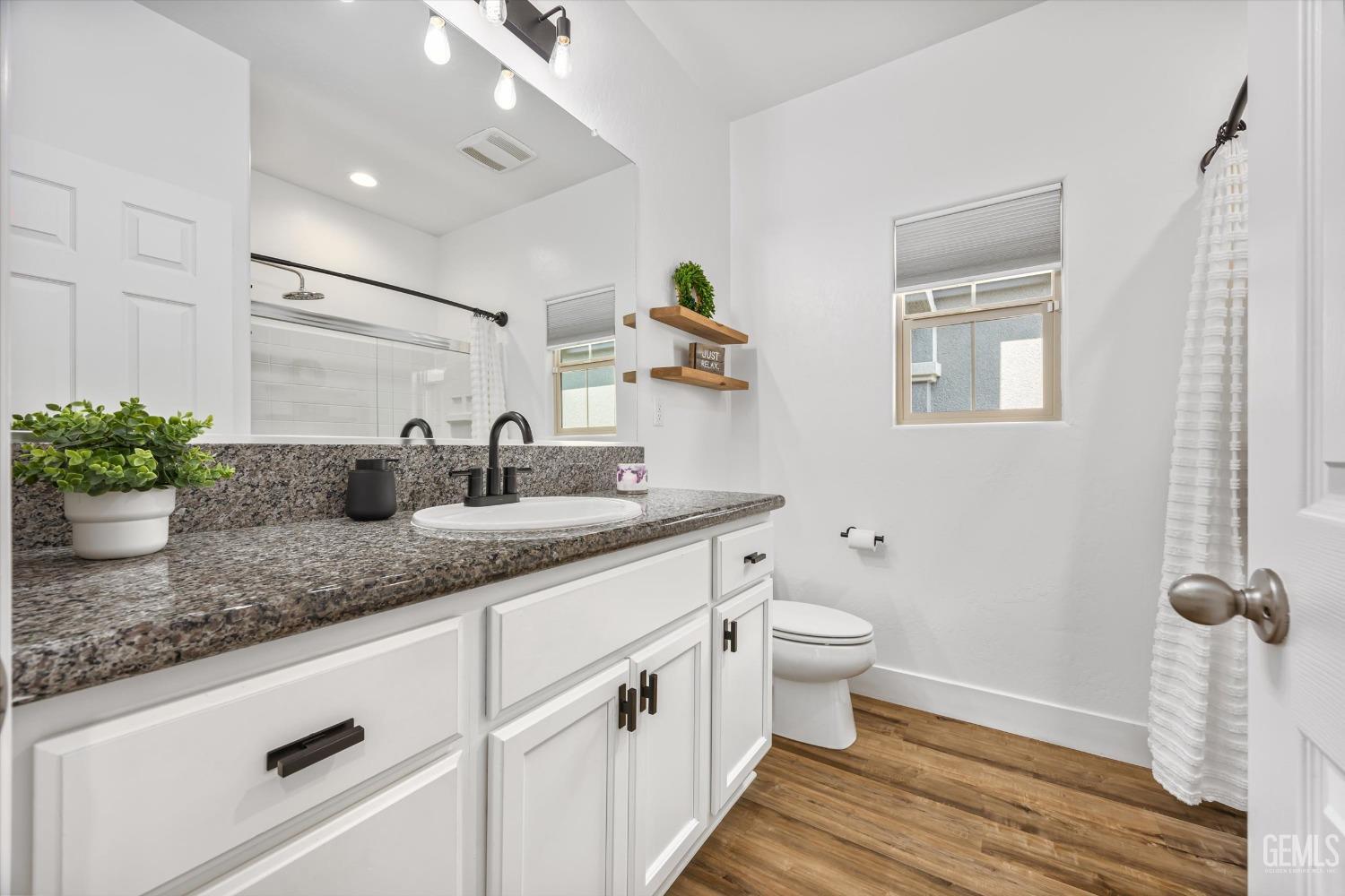 Undisclosed Address Bakersfield, CA 93314 - Photo 31 of 43 a bathroom with a granite countertop sink mirror and toilet