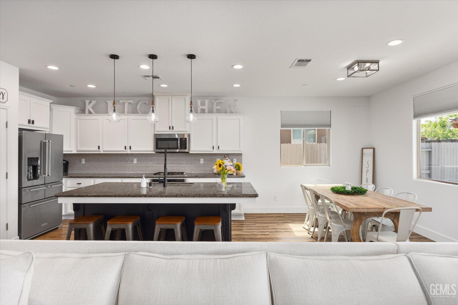 Undisclosed Address Bakersfield, CA 93314 - Photo 8 of 43 a kitchen with kitchen island stainless steel appliances a sink and a refrigerator