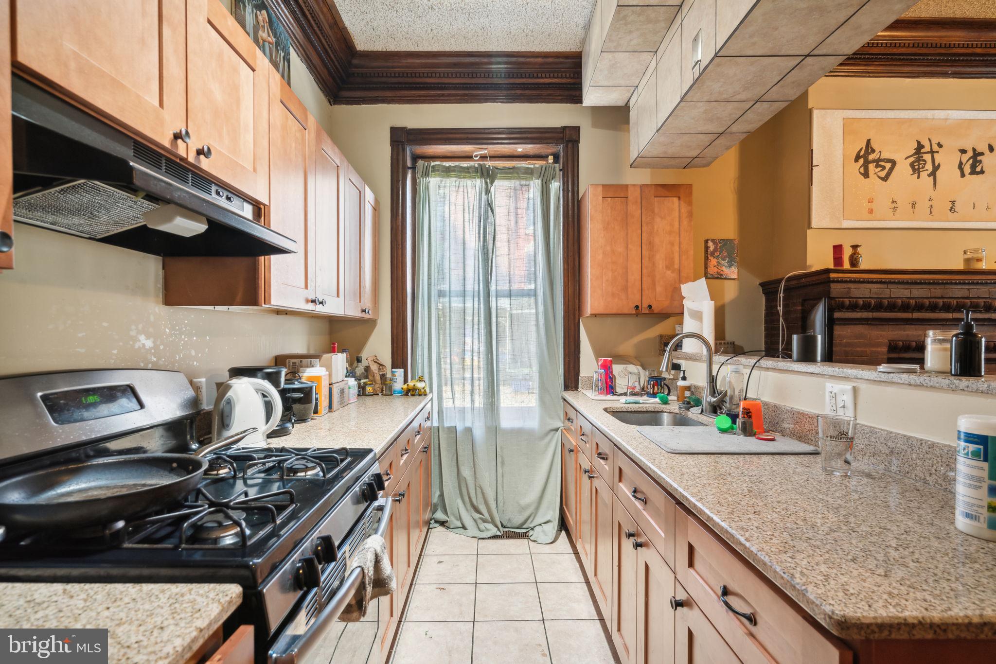 4036 Spring Garden Street Philadelphia, PA 19104 - Photo 5 of 46 a kitchen with stainless steel appliances granite countertop a stove a sink and a wooden cabinets