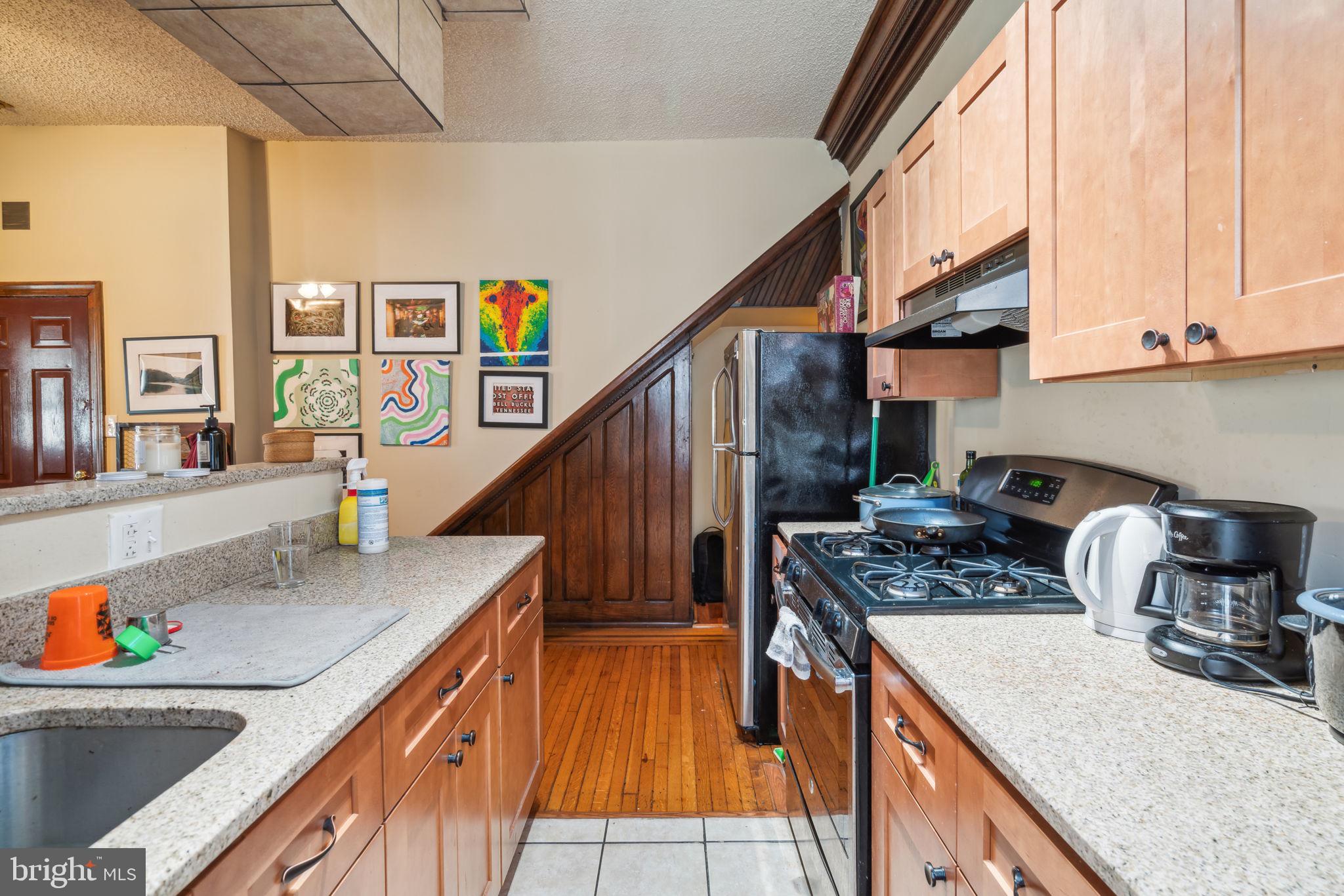 4036 Spring Garden Street Philadelphia, PA 19104 - Photo 6 of 46 a kitchen with stainless steel appliances granite countertop a sink a stove and a wooden floors