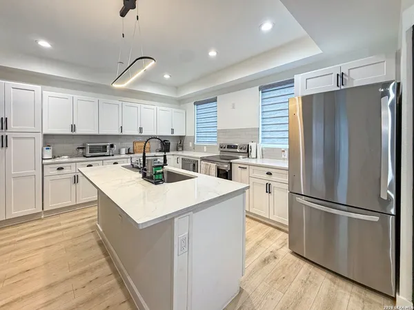 a kitchen with a refrigerator a sink and a stove top oven