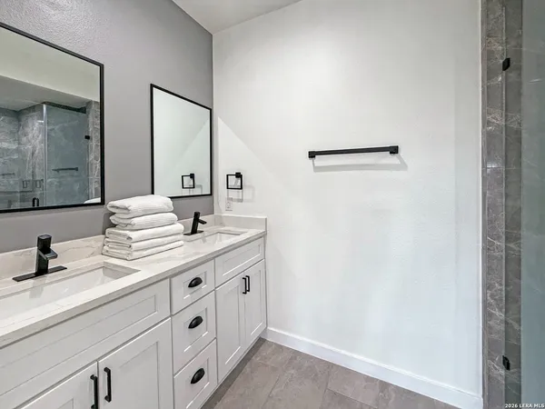 a bathroom with a double vanity sink and a mirror