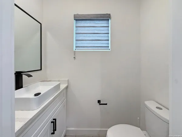a bathroom with a sink toilet and mirror