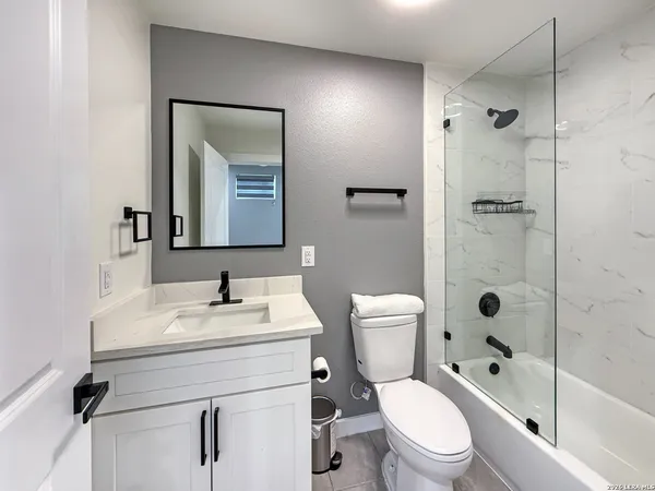 a bathroom with a toilet sink vanity tub and shower