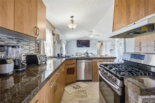 a kitchen with stainless steel appliances granite countertop a stove and a sink