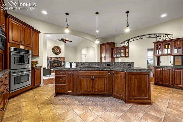 a large kitchen with stainless steel appliances granite countertop a stove a sink and a refrigerator