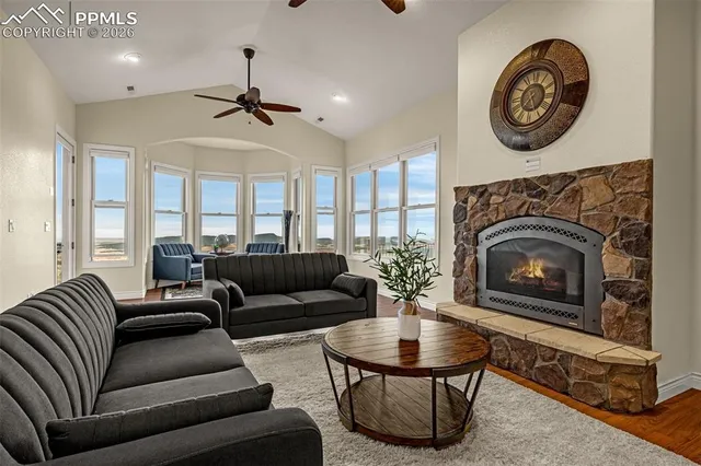 a living room with furniture a clock and a fireplace
