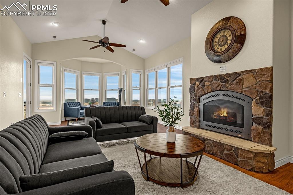 15575 Henry Ride Heights Colorado Springs, CO 80926 - Photo 16 of 46 a living room with furniture a clock and a fireplace