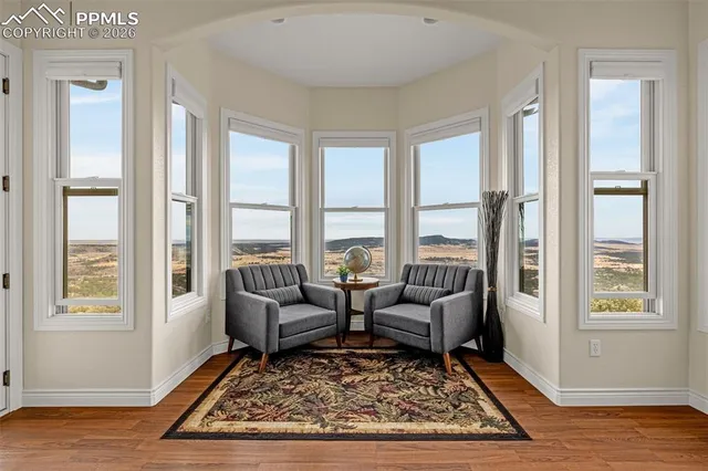 a living room with large windows next to a rug