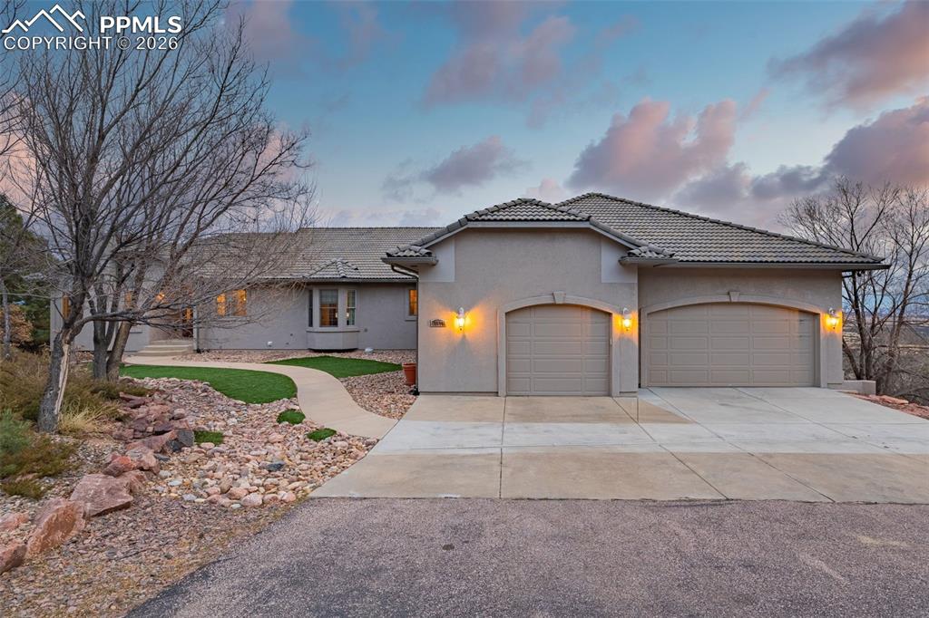 15575 Henry Ride Heights Colorado Springs, CO 80926 - Photo 2 of 46 a front view of a house with a yard and garage
