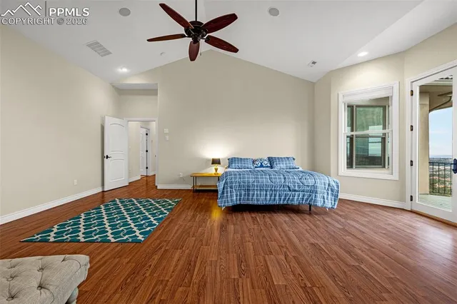 a living room with a bed and wooden floor