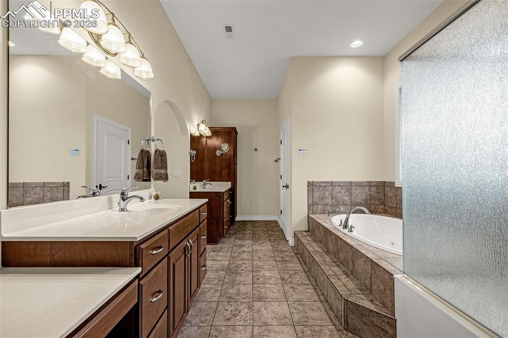 15575 Henry Ride Heights Colorado Springs, CO 80926 - Photo 27 of 46 a bathroom with a tub sink and mirror