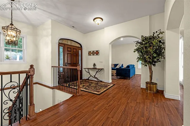 a living room with furniture a potted plant and open to kitchen view