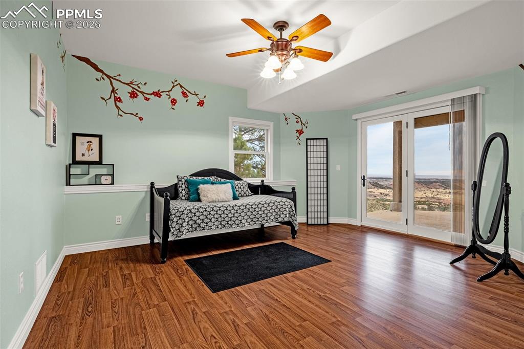 15575 Henry Ride Heights Colorado Springs, CO 80926 - Photo 34 of 46 a bedroom with a bed and a chandelier