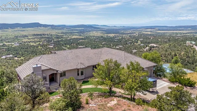 an aerial view of house with yard and mountain view in back